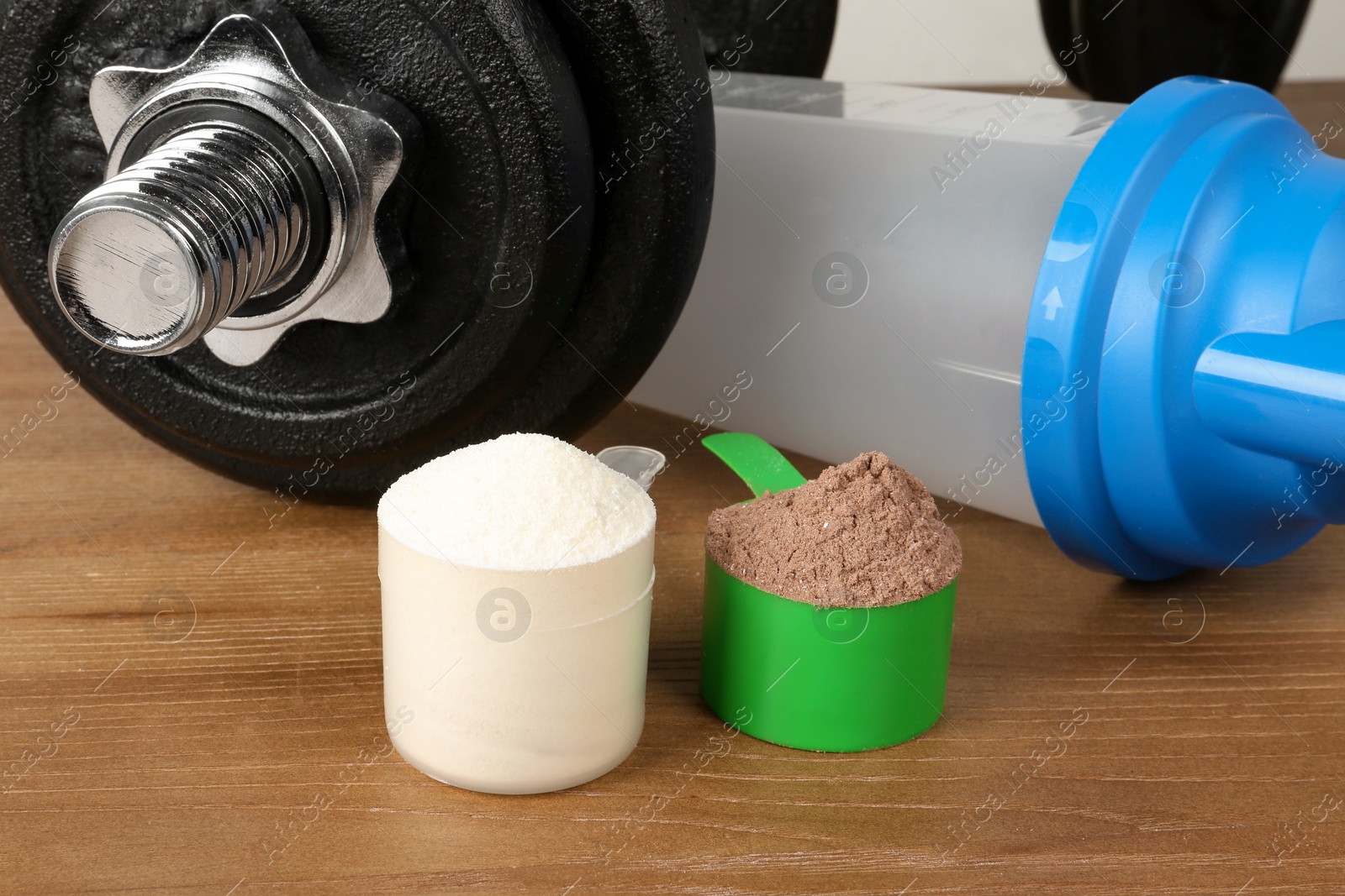 Photo of Scoops with protein shake powders on table, closeup