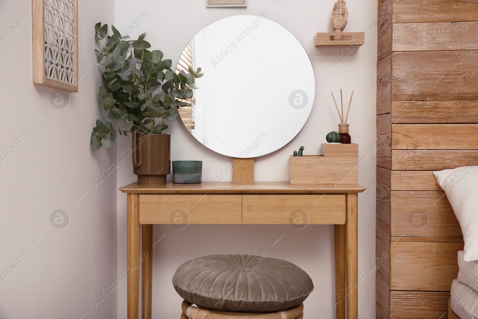 Photo of Stylish dressing table and mirror near white wall indoors. Interior design