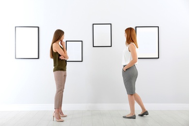 Photo of People viewing exposition in modern art gallery