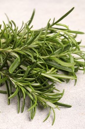 Photo of Fresh rosemary on light textured table, closeup