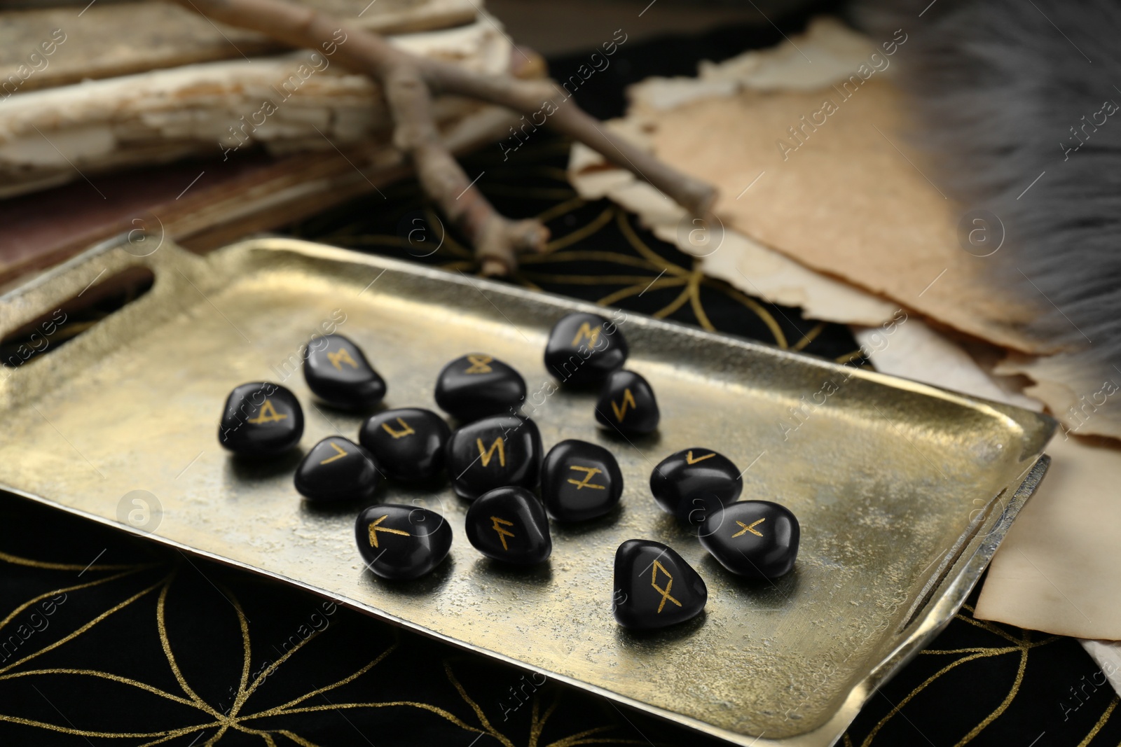 Photo of Tray with many black rune stones on divination mat, closeup
