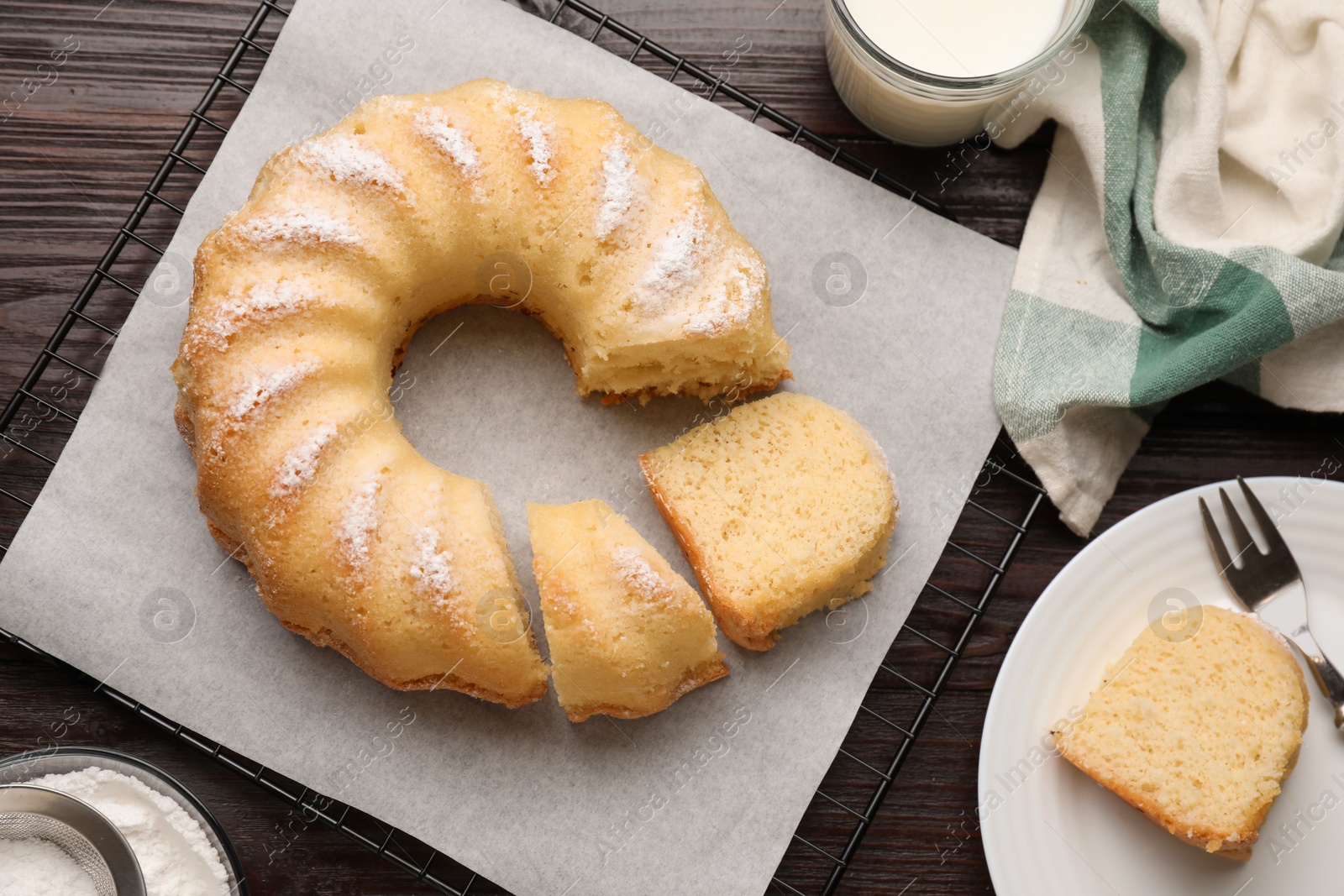 Photo of Delicious sponge cake served on wooden table, flat lay