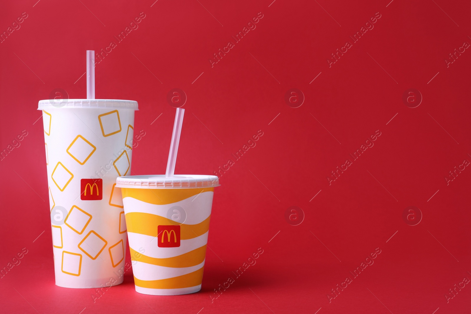 Photo of MYKOLAIV, UKRAINE - AUGUST 12, 2021: Cold McDonald's drinks on red background. Space for text