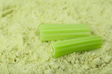 Fresh stalks on natural celery powder, closeup. Space for text