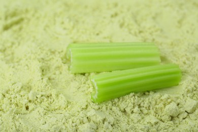 Photo of Fresh stalks on natural celery powder, closeup. Space for text