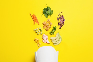 Photo of Flat lay composition with ingredients for salad and paper container on yellow background