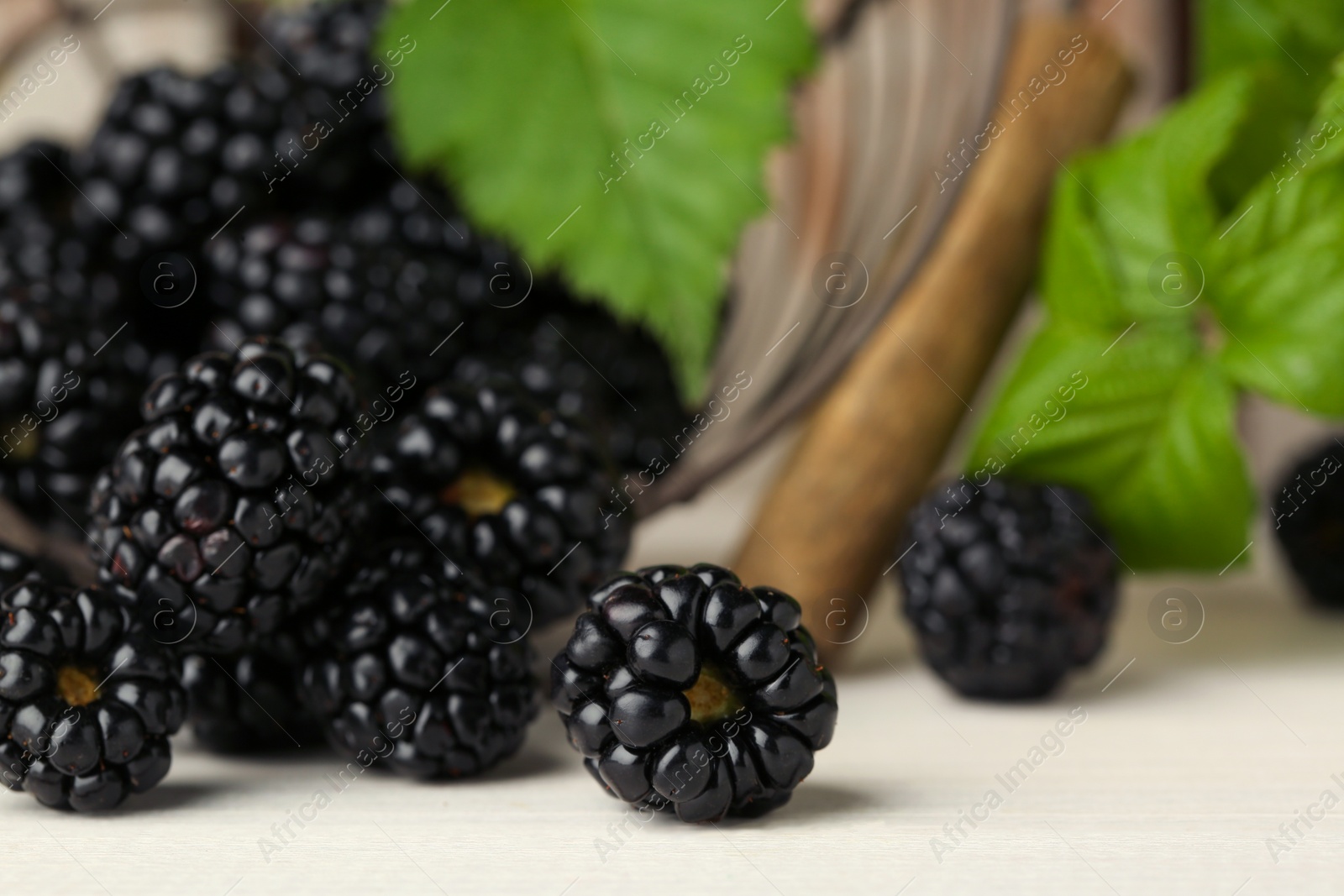 Photo of Fresh ripe blackberries on white wooden table, closeup