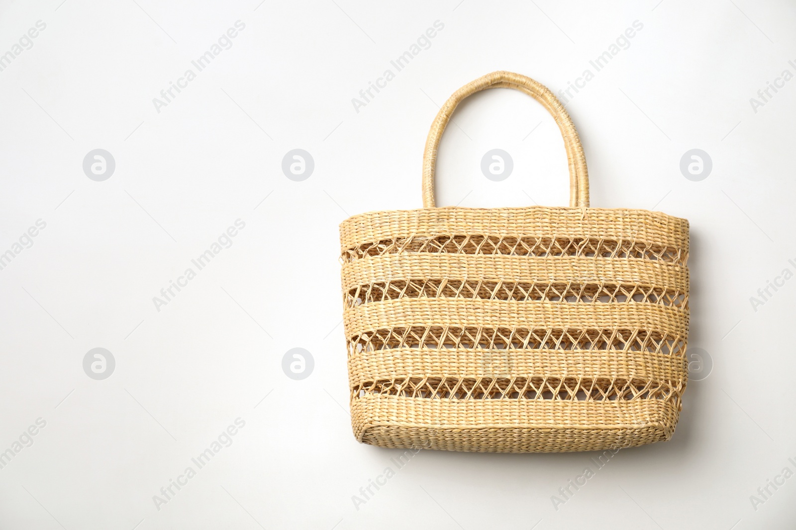 Photo of Stylish straw bag on white background, top view. Summer accessory