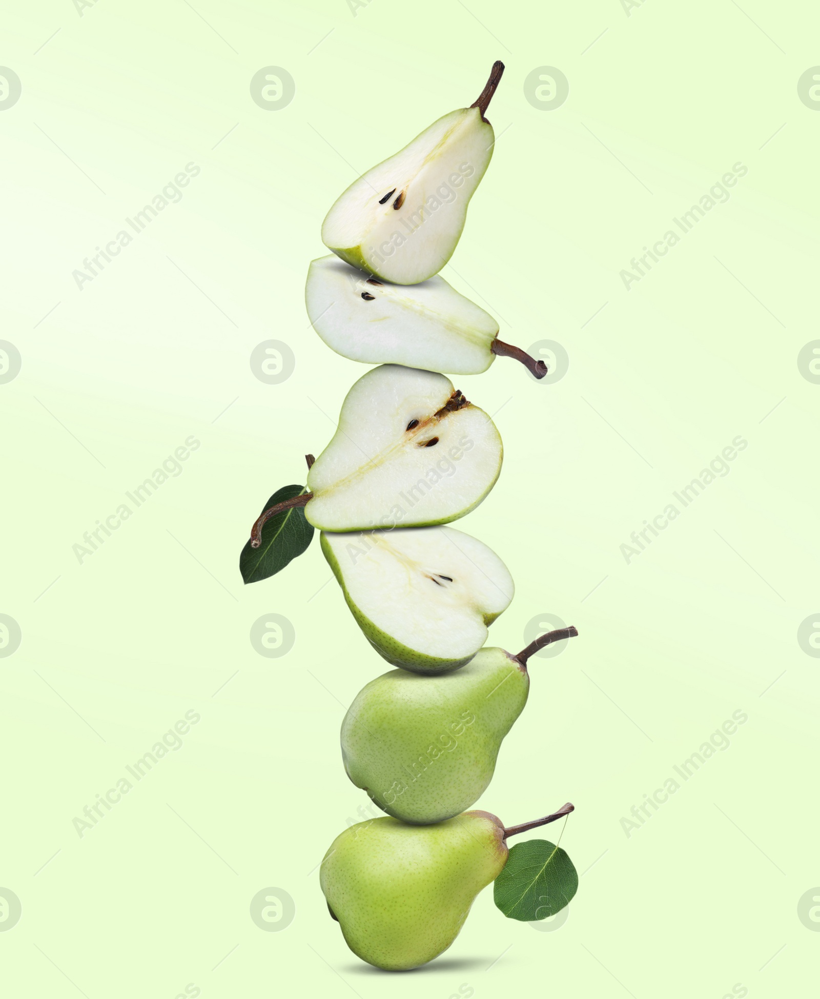 Image of Cut and whole fresh ripe pears on light green background