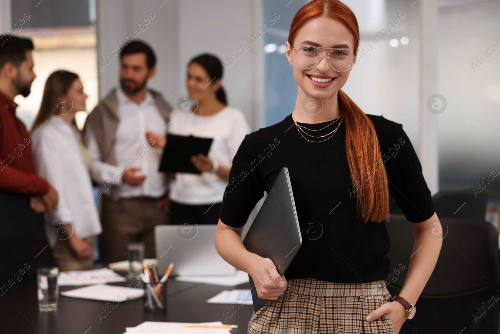 Photo of Team of employees working together in office. Happy businesswoman with laptop indoors