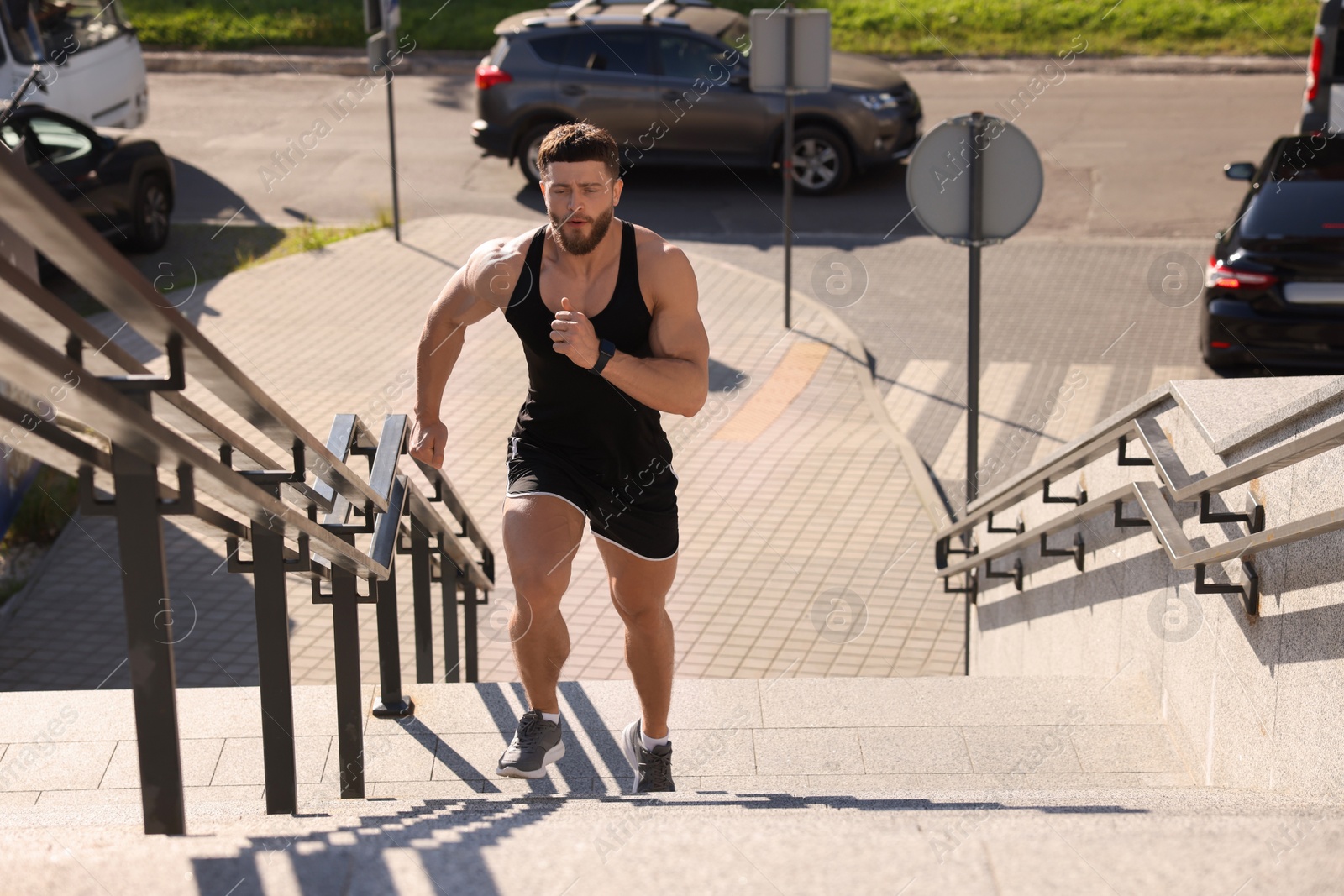 Photo of Man running up stairs outdoors on sunny day