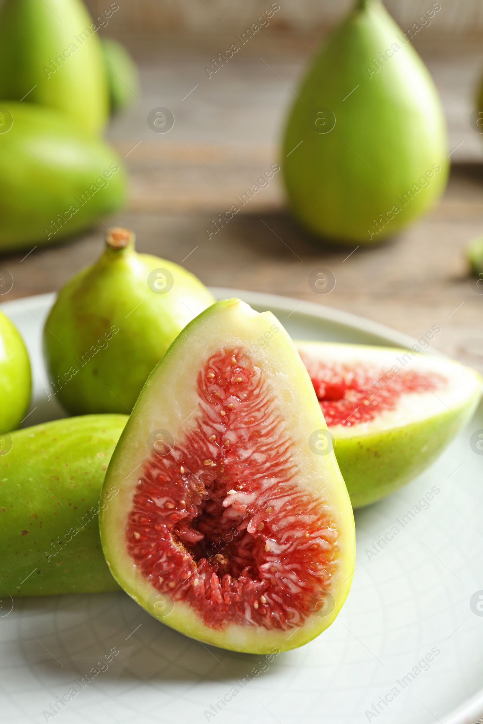 Photo of Plate with fresh ripe figs on table. Tropical fruit