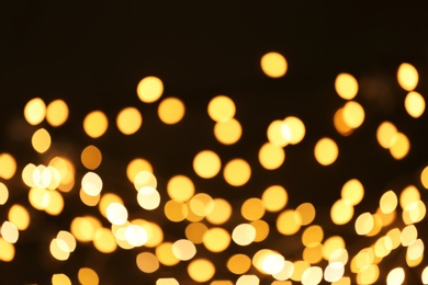 Photo of Beautiful golden lights on dark background. Bokeh effect