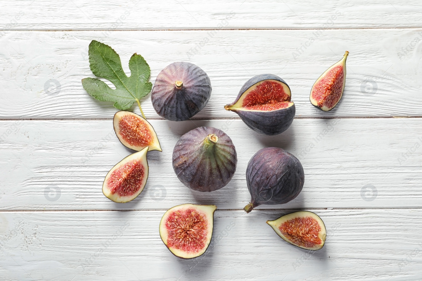 Photo of Flat lay composition with whole and cut purple figs on wooden background