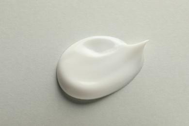 Sample of face cream on light background, top view