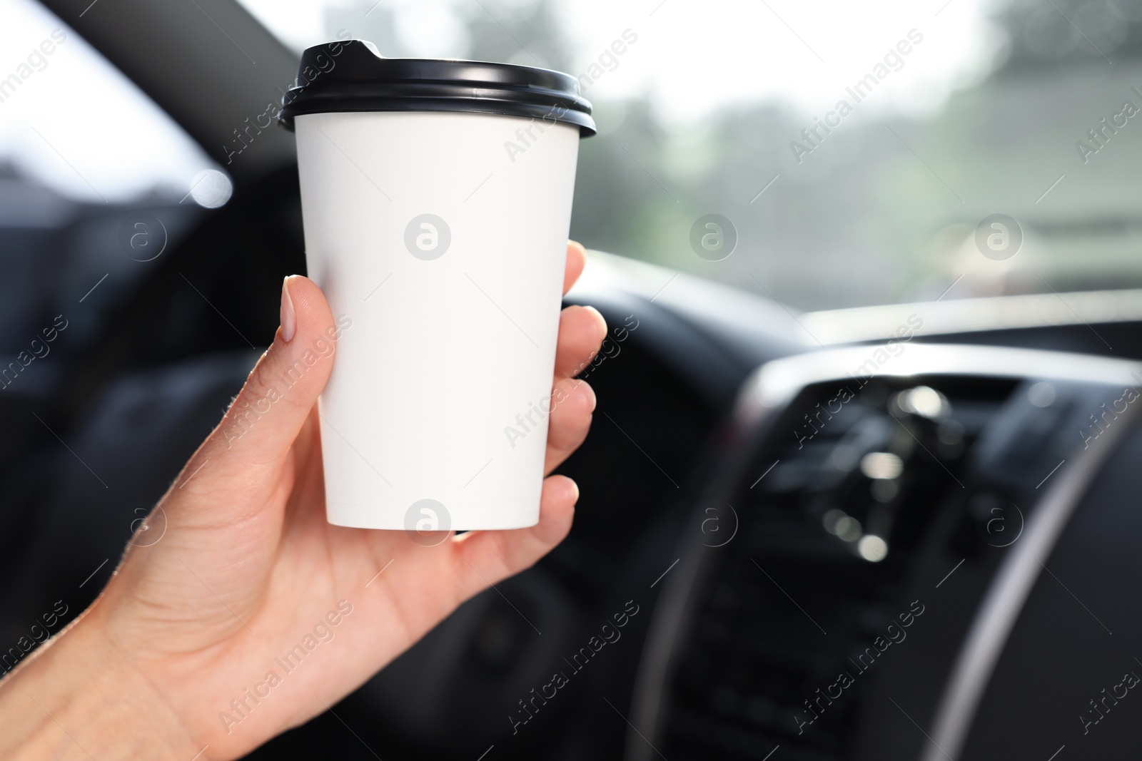 Photo of Coffee to go. Woman with paper cup of drink in car, closeup and space for text