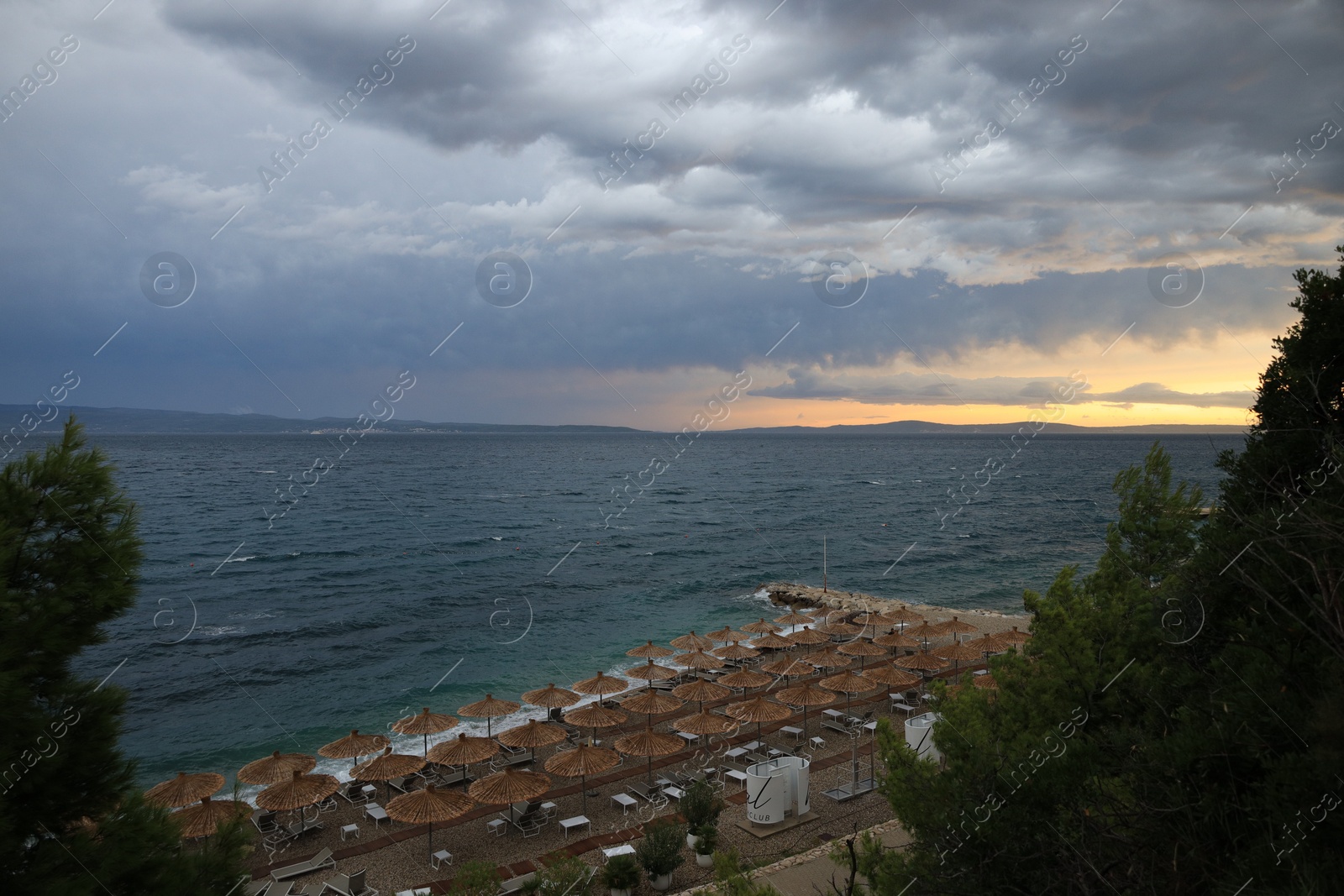 Photo of Beautiful view of seaside resort with straw umbrellas and sunbeds