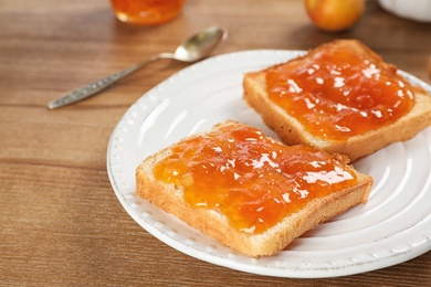 Photo of Bread with tasty apricot jam on plate