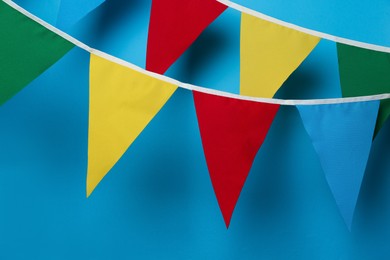Photo of Buntings with colorful triangular flags on light blue background