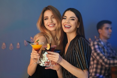 Photo of Beautiful young women with martini cocktails in bar