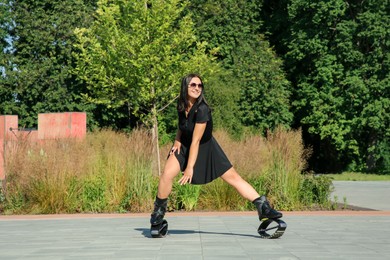 Photo of Woman doing exercises in kangoo jumping boots outdoors