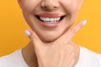 Photo of Woman with clean teeth smiling on yellow background, closeup