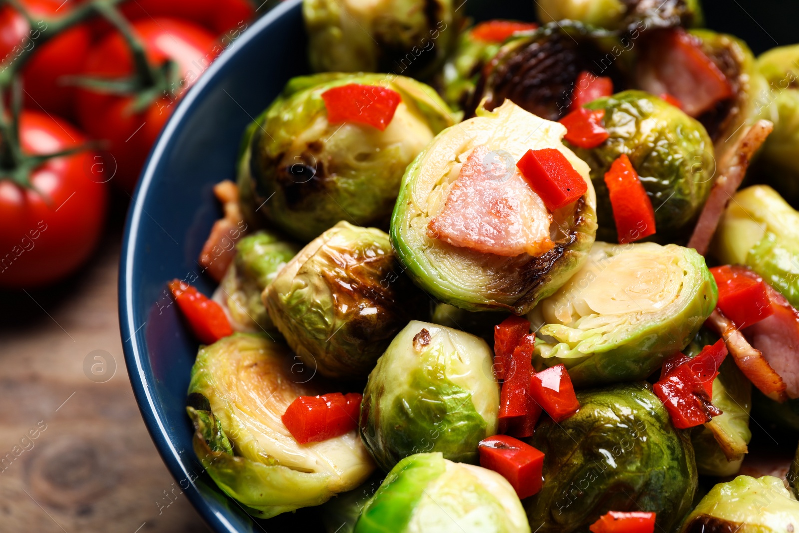 Photo of Delicious Brussels sprouts with bacon in bowl, closeup