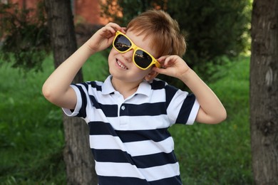 Photo of Cute little boy with sunglasses in park