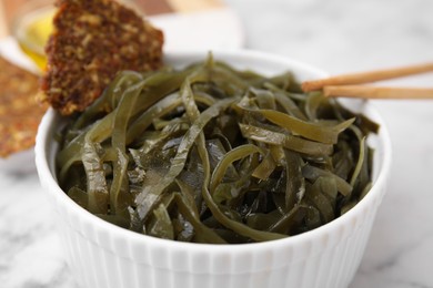 Tasty seaweed salad in bowl served on table, closeup