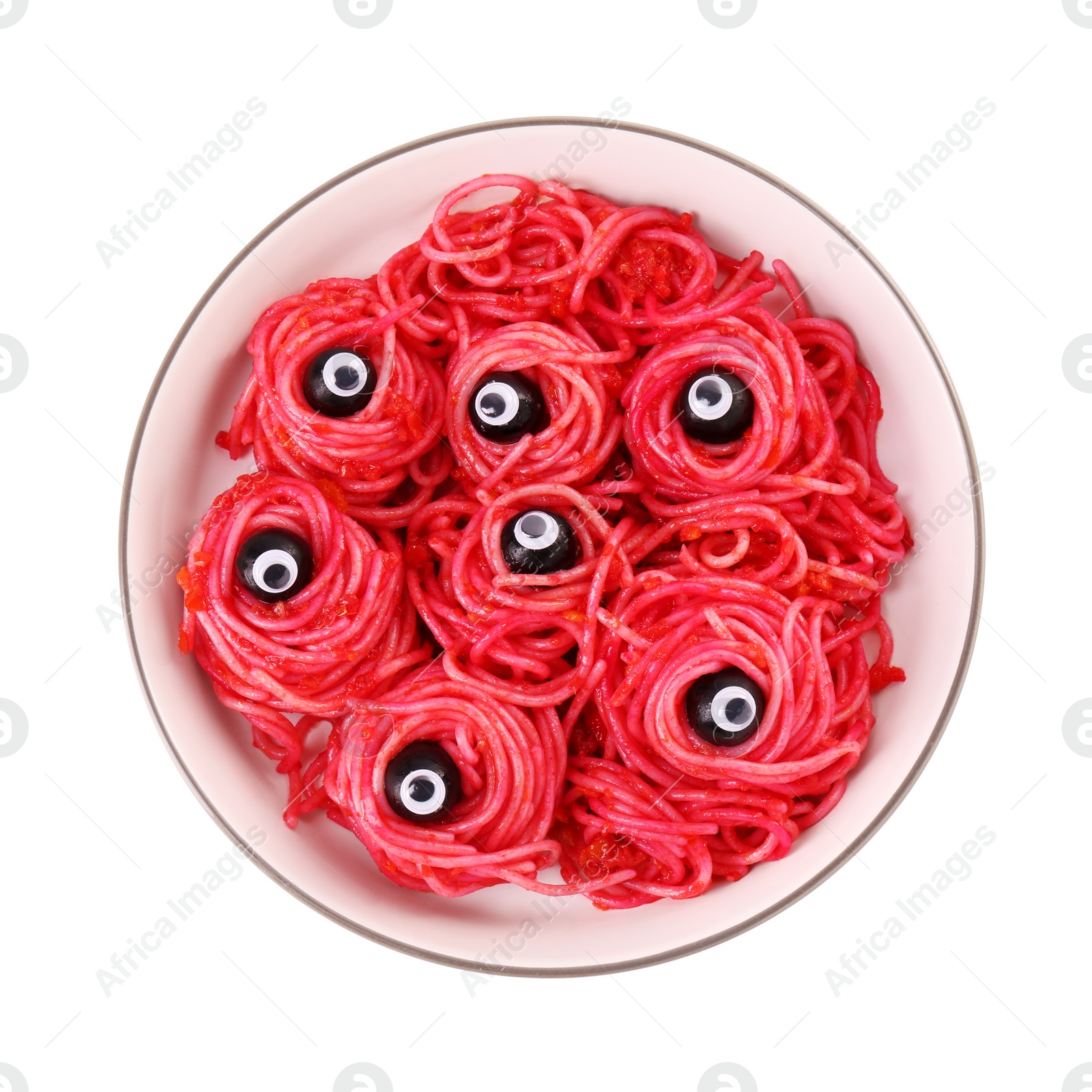 Photo of Red pasta with decorative eyes and olives in bowl isolated on white, top view. Halloween food