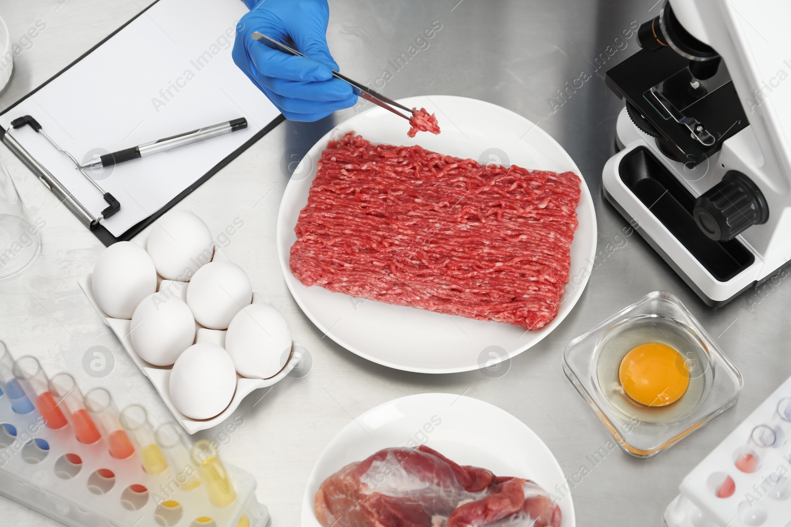 Photo of Scientist checking meat at table in laboratory, above view. Quality control