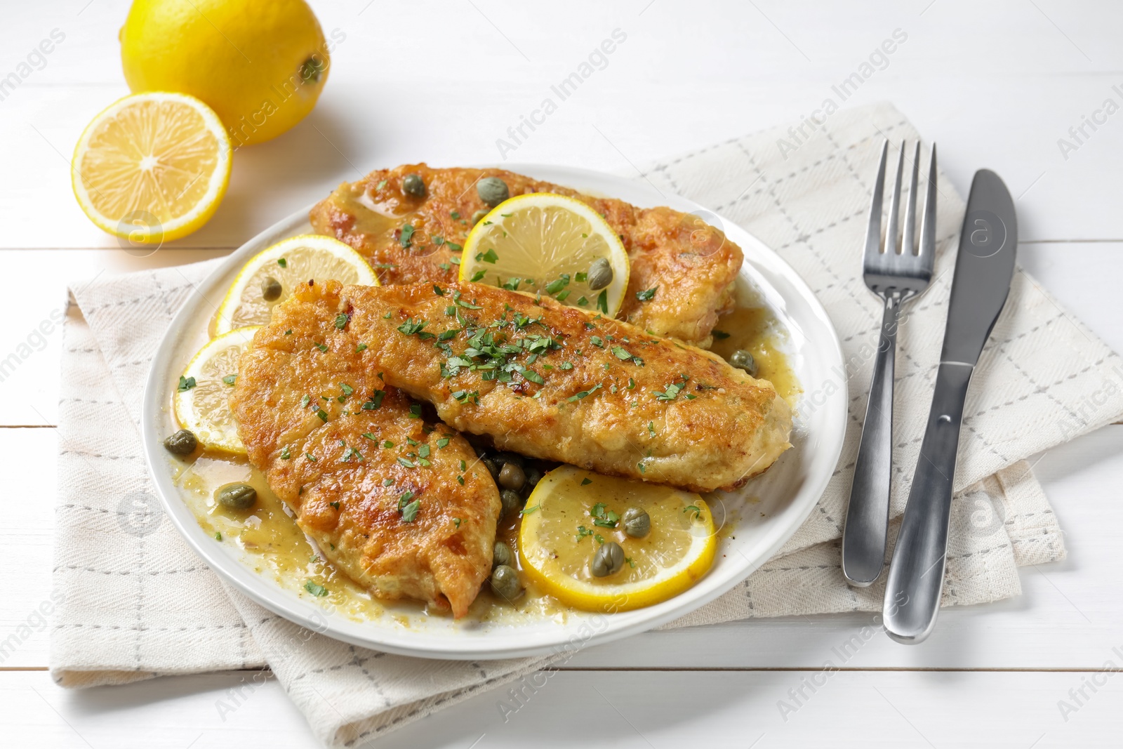 Photo of Delicious chicken piccata served on white table