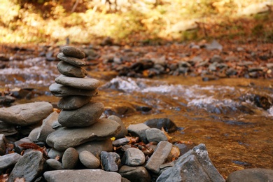 Stack of stones near water. Space for text