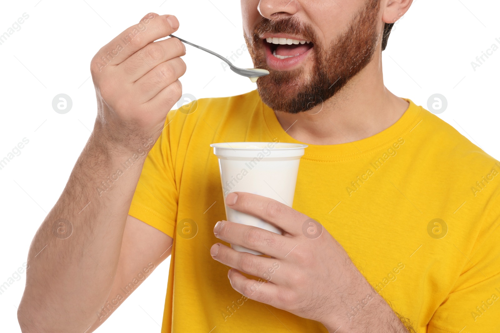 Photo of Man eating delicious yogurt on white background, closeup