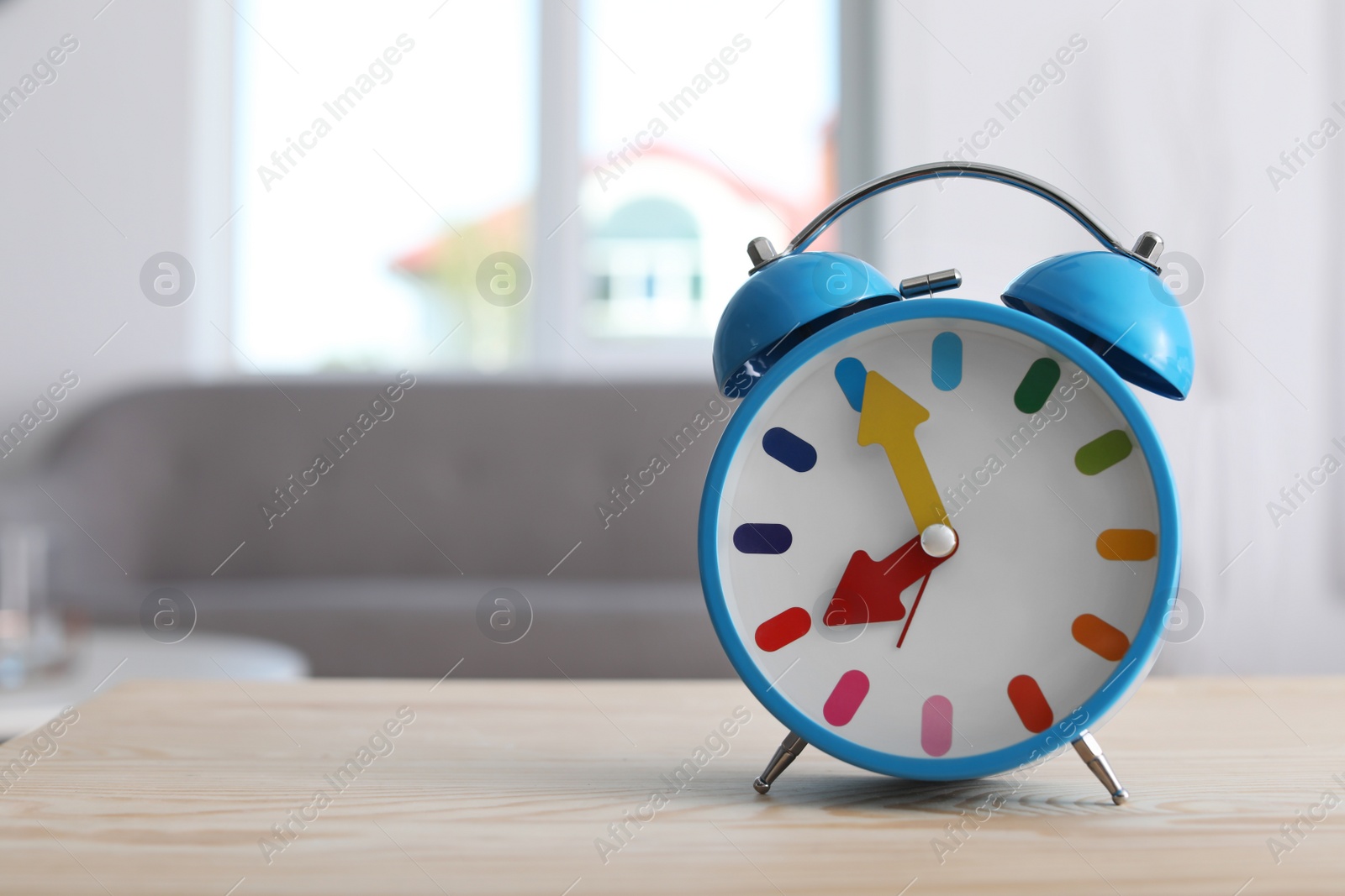 Photo of Colorful alarm clock on table in living room