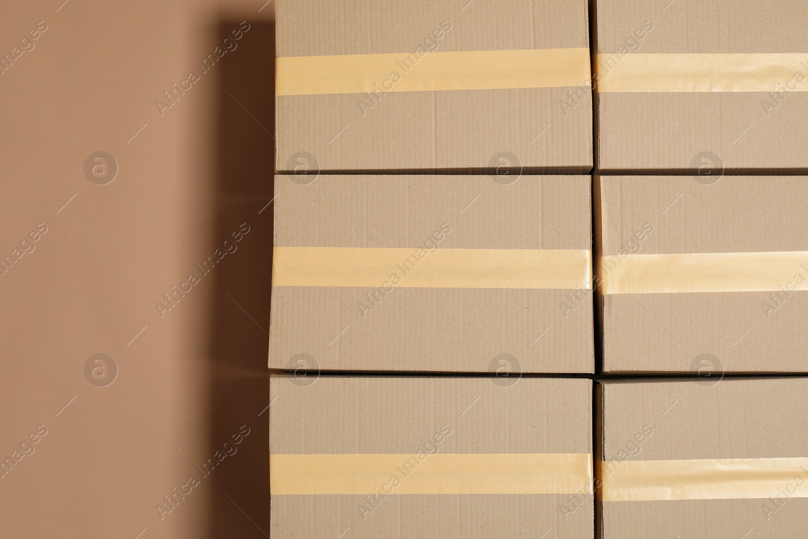 Photo of Cardboard boxes on light brown background, flat lay. Space for text