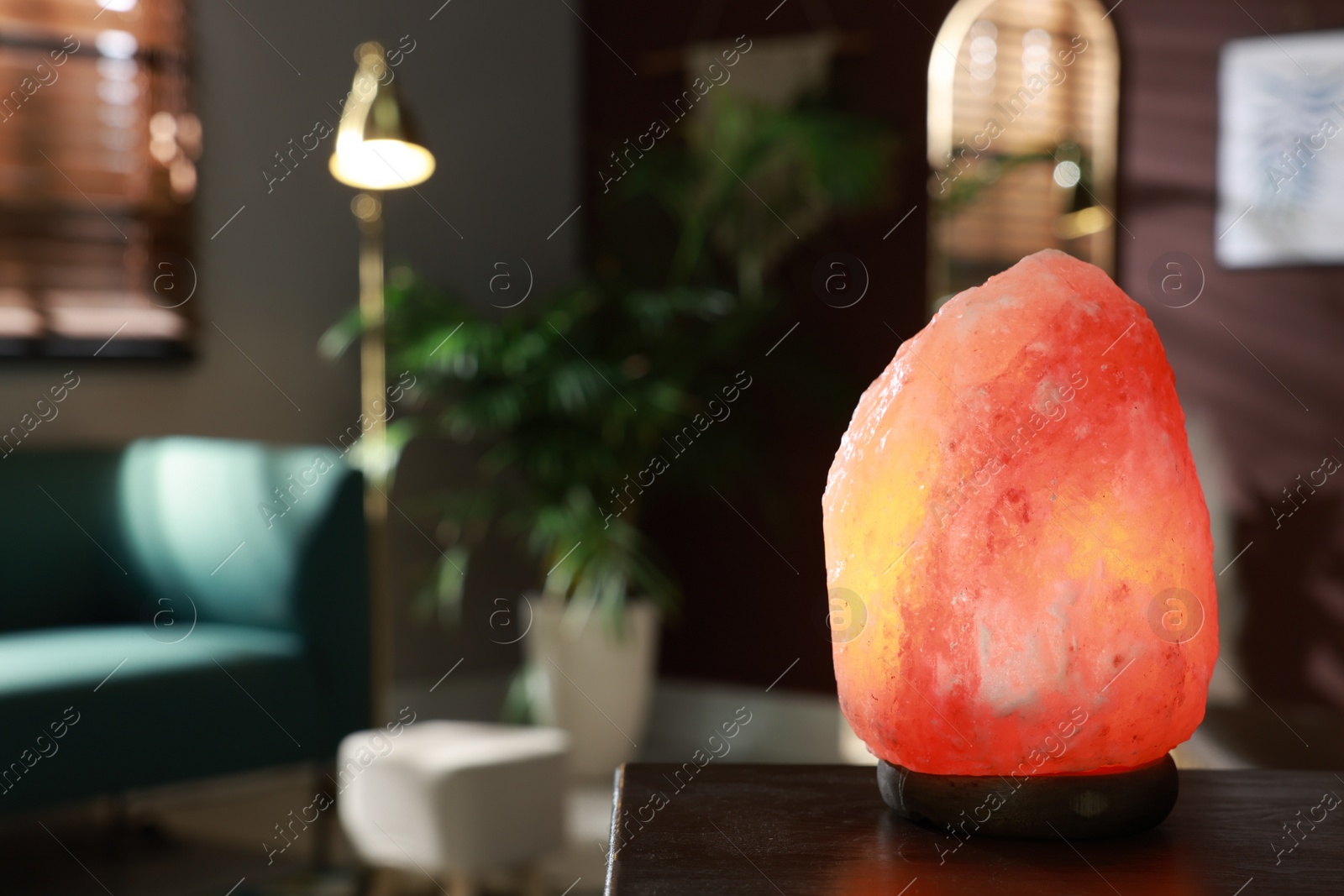 Photo of Himalayan salt lamp on wooden table indoors, space for text