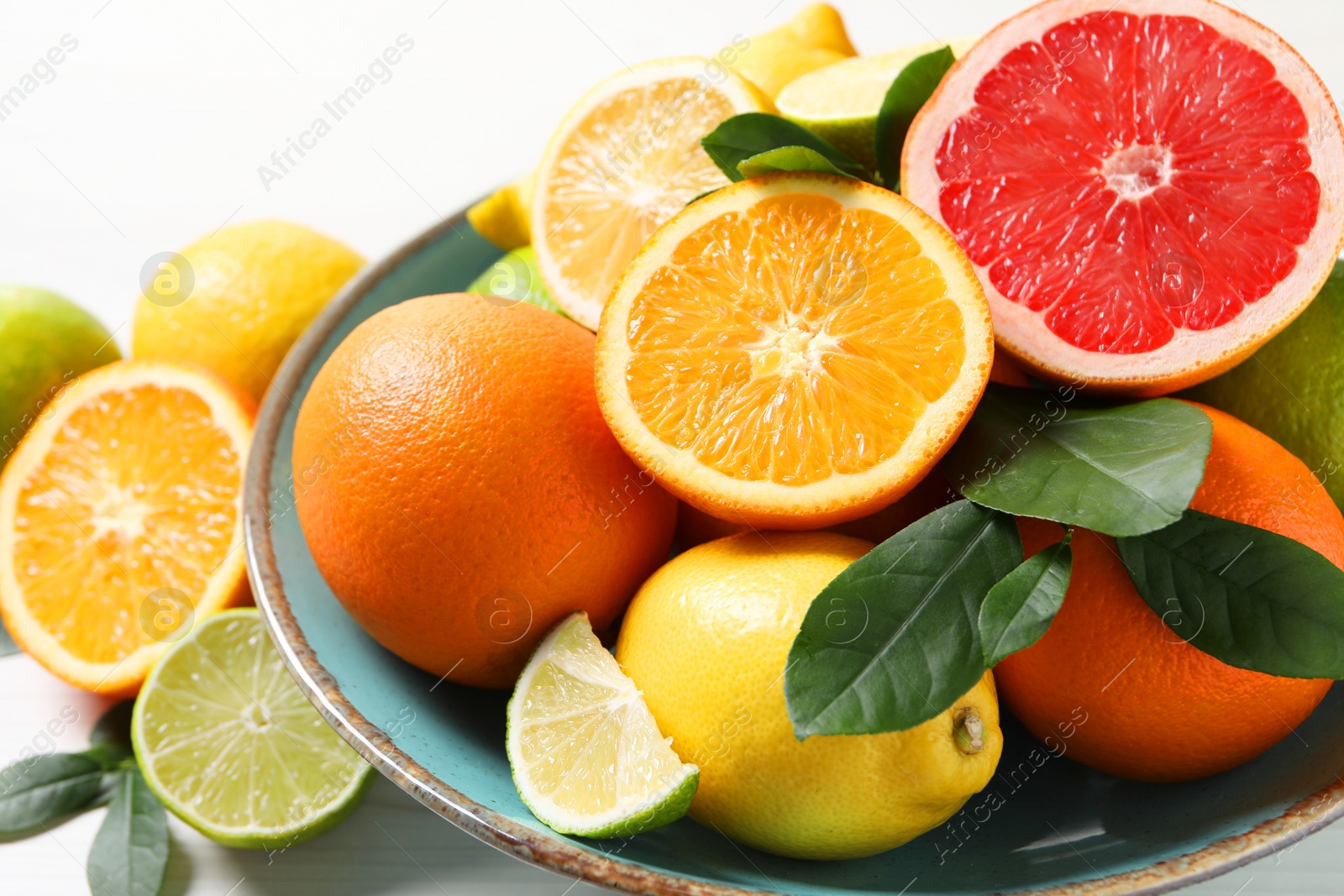 Photo of Different cut and whole citrus fruits on white table, closeup