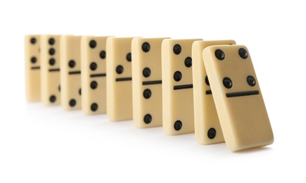 Photo of Light domino tiles falling on white background