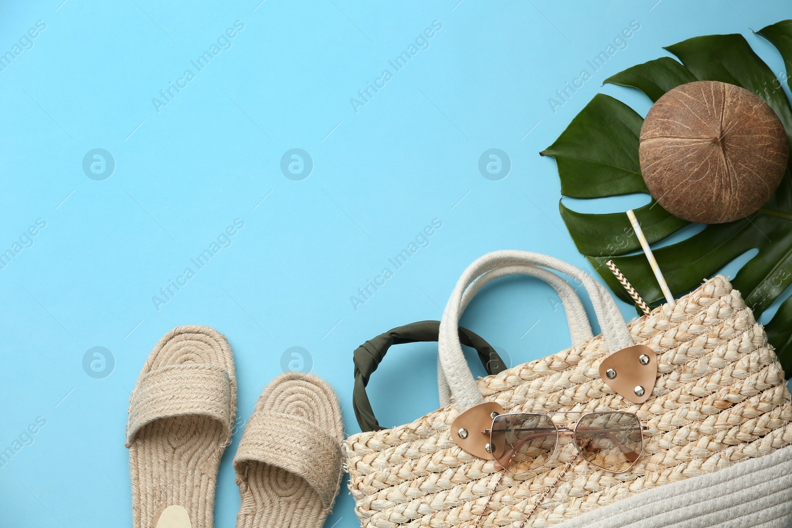 Photo of Flat lay composition with woman's straw bag on light blue background. Space for text