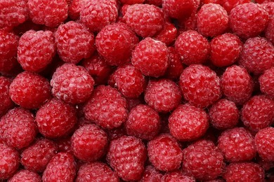 Photo of Heap of tasty ripe raspberries as background, top view