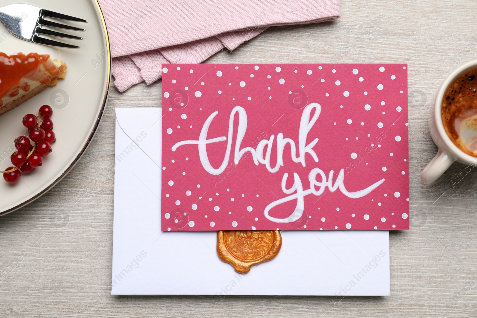 Photo of Card with phrase Thank You, cheesecake and coffee on light wooden table, flat lay