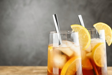 Photo of Glasses of refreshing iced tea against grey background, closeup. Space for text