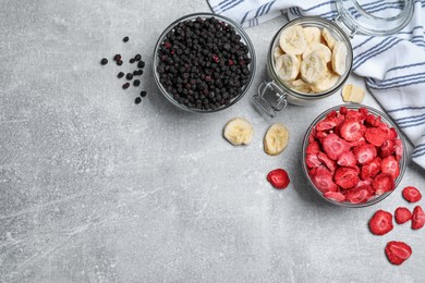 Many different freeze dried fruits on light grey table, flat lay. Space for text