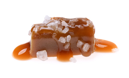 Photo of Delicious salted caramel with sauce on white background