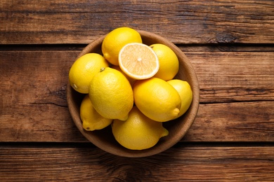 Many fresh ripe lemons on wooden table, top view