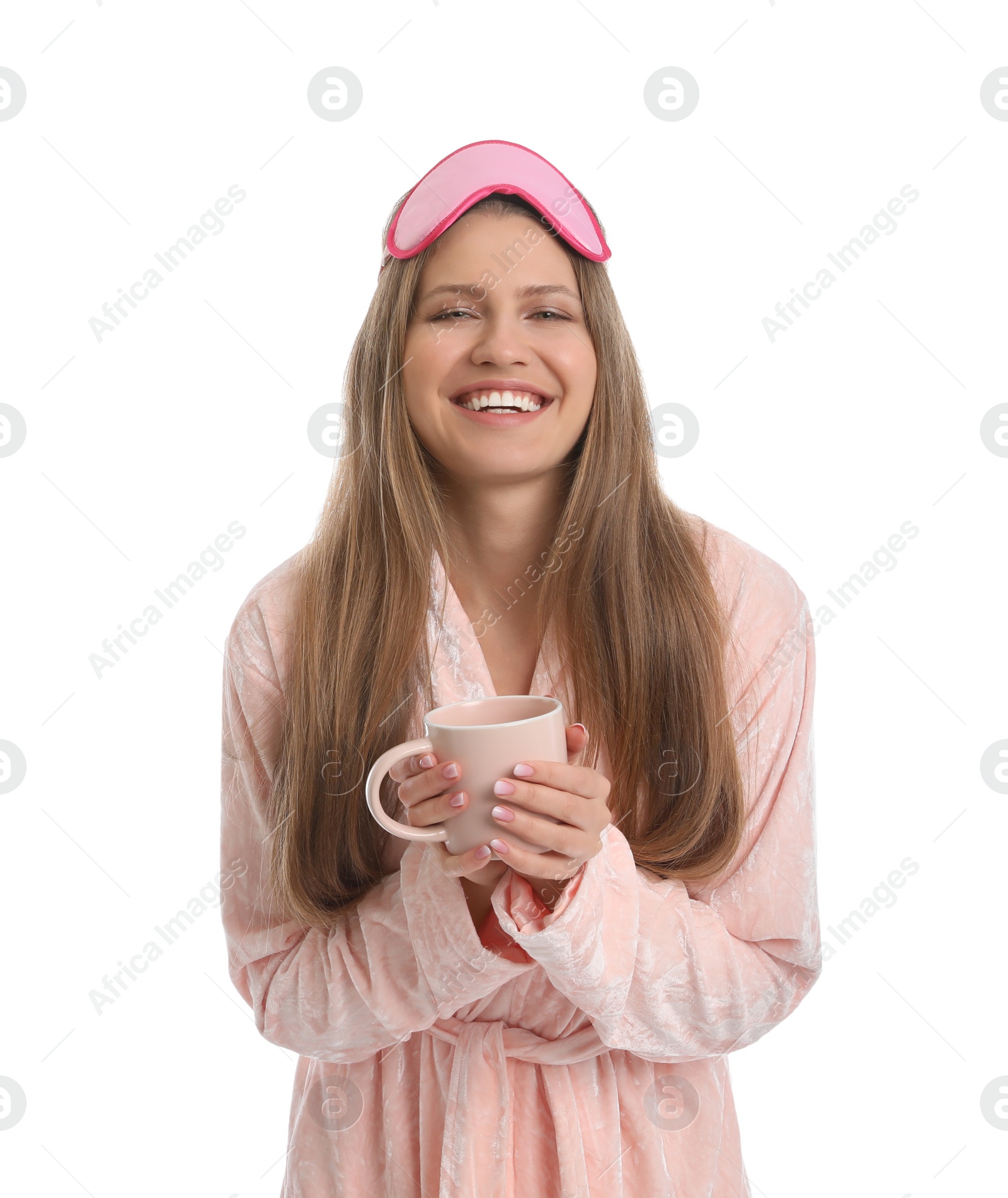 Photo of Young woman in bathrobe with sleep mask and cup of beverage on white background