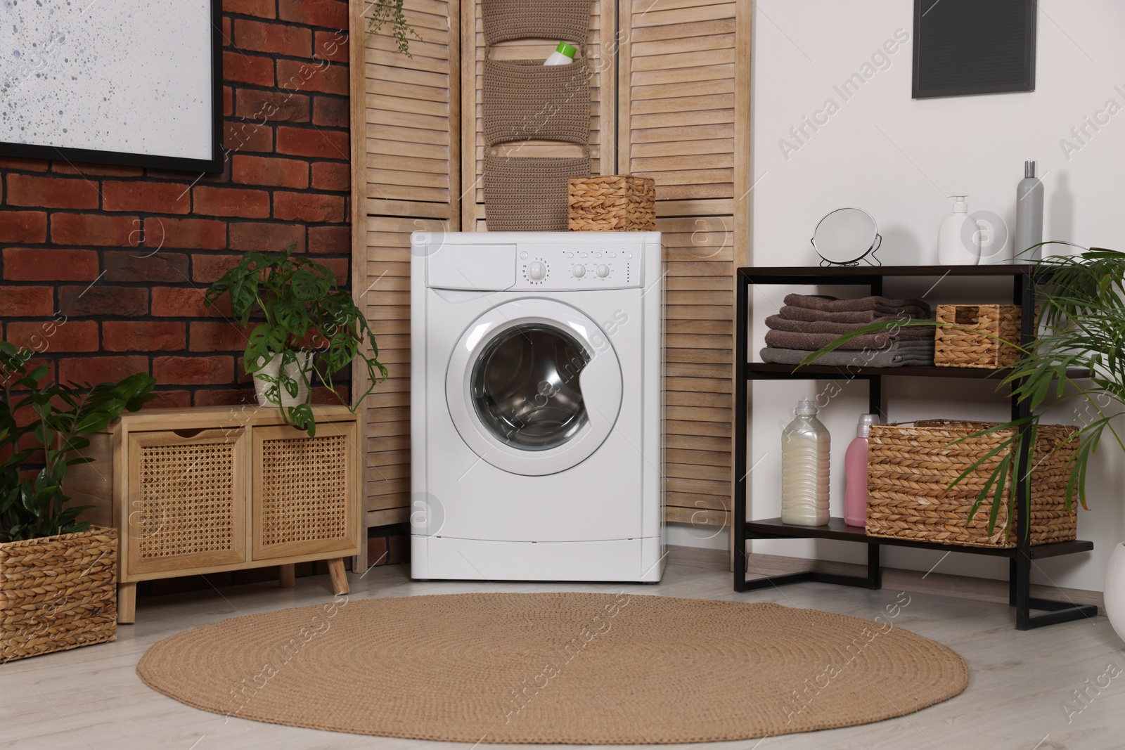 Photo of Stylish laundry room with washing machine. Interior design