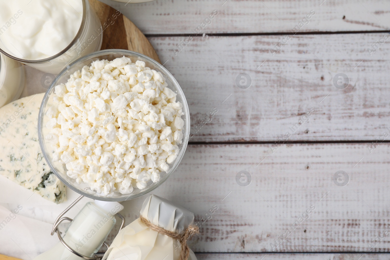 Photo of Different fresh dairy products on white wooden table, flat lay. Space for text