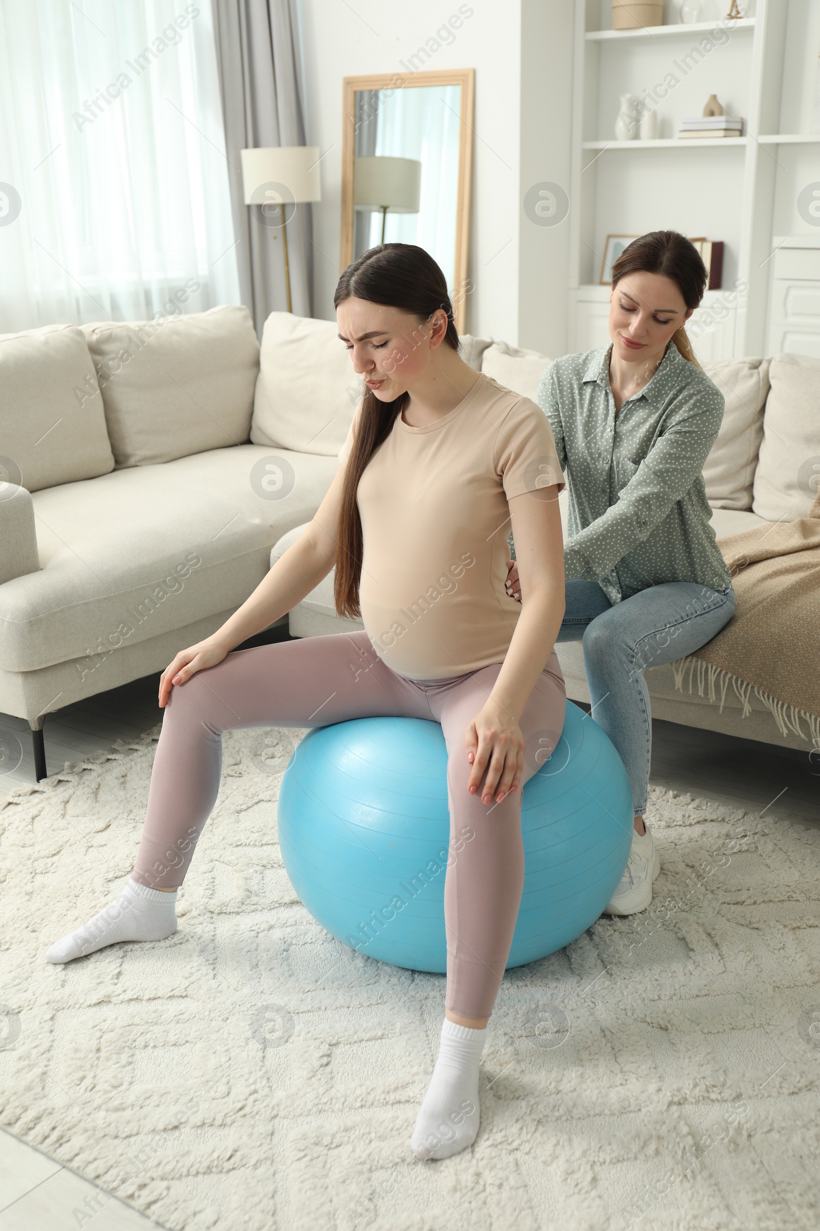 Photo of Doula working with pregnant woman at home. Preparation for child birth